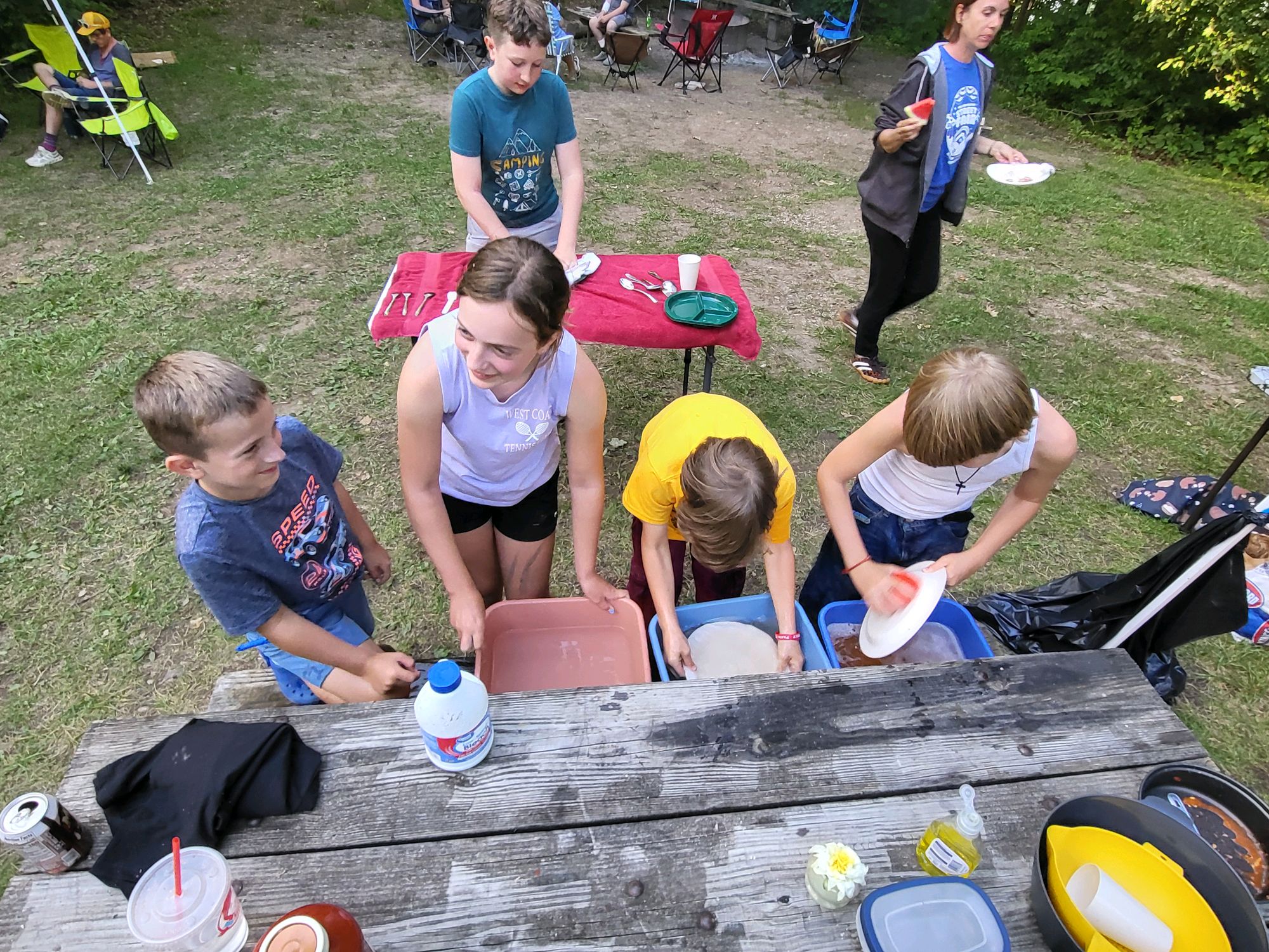 Scouts washing dishes together at camp