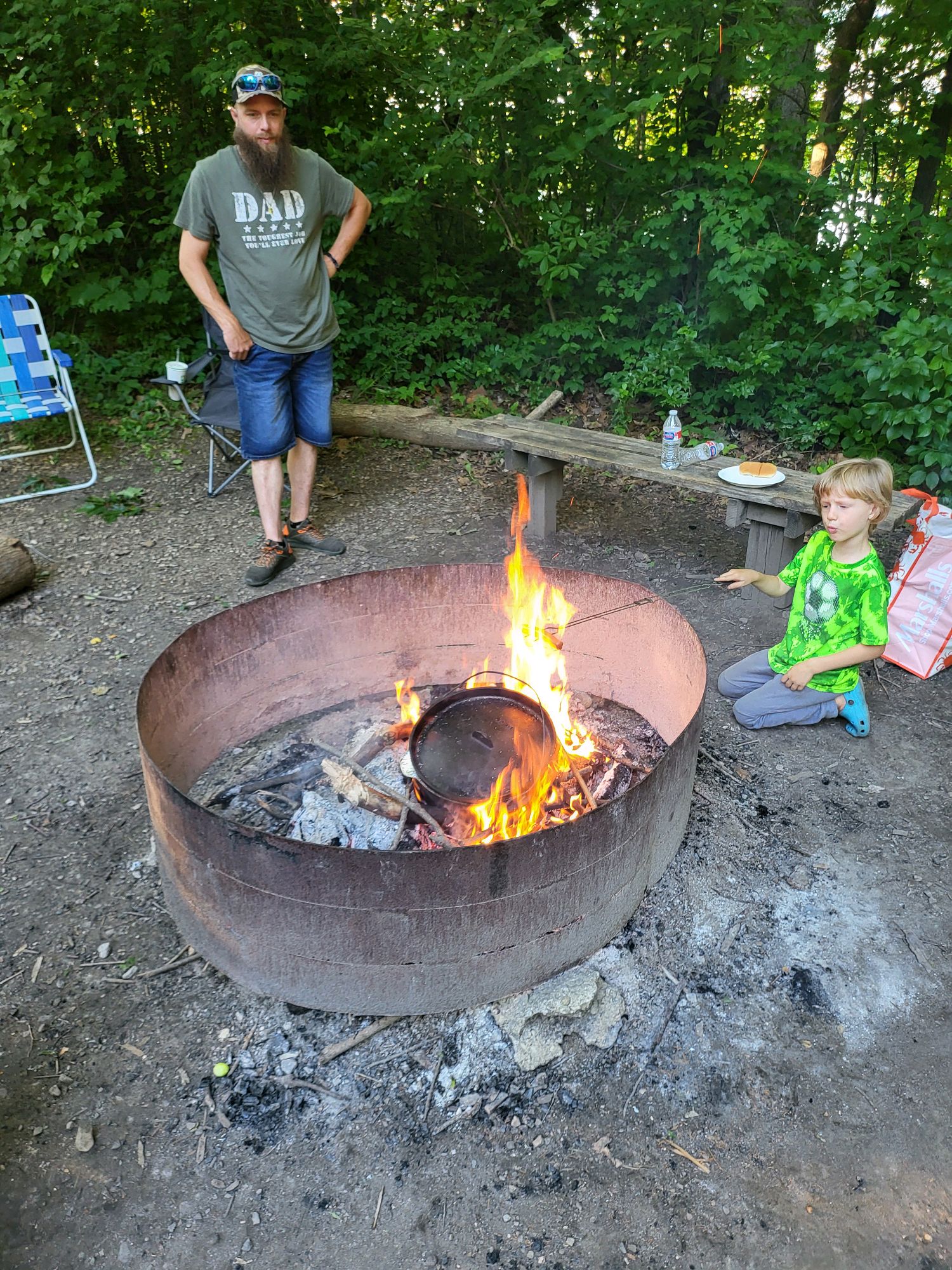 Scout roasting food over the campfire ring