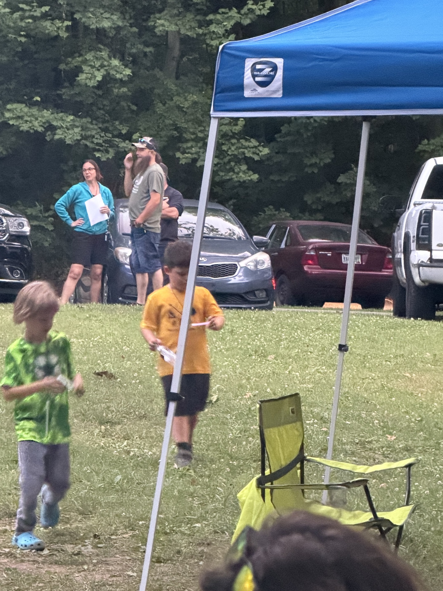 Scouts playing near the blue canopy at camp