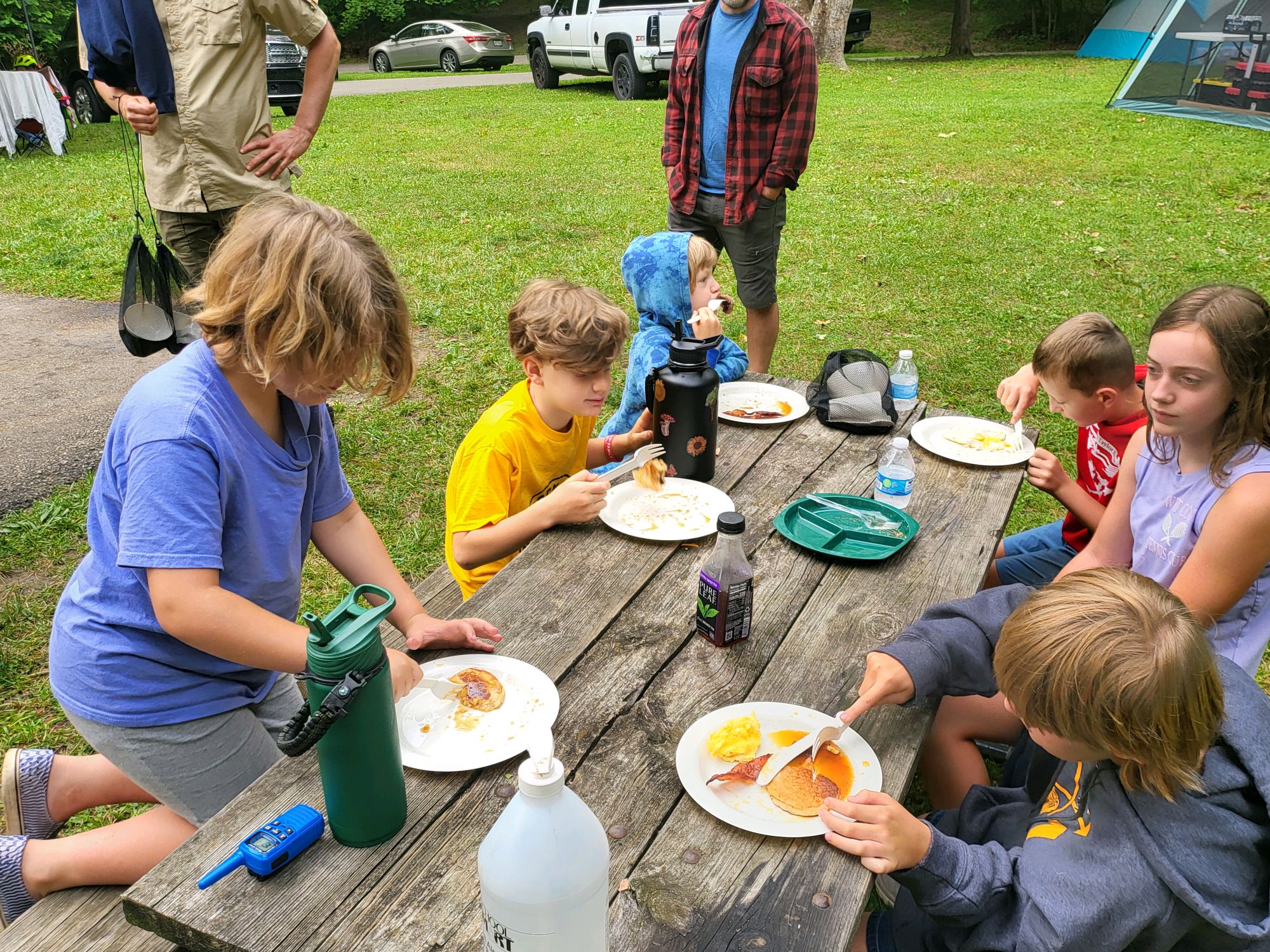 Scouts eating pancakes at a picnic table