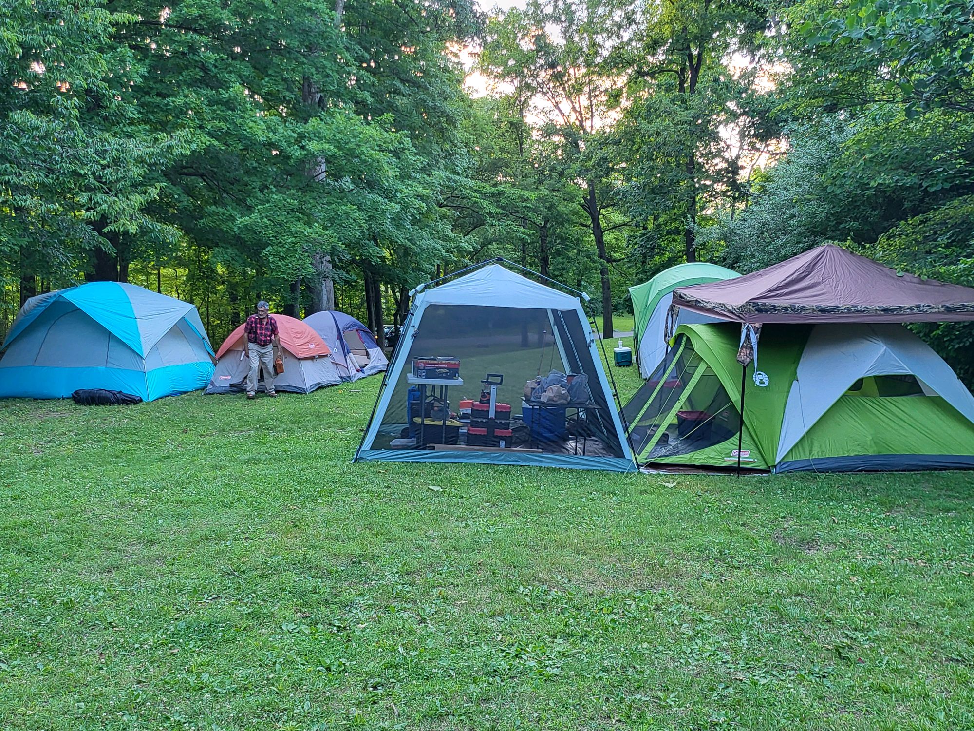 Row of colorful tents and screen canopy set up at the Pack 131 campsite